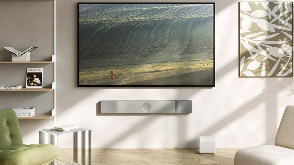 KEF XIO soundbar in silver grey mounted on wall, showcasing sleek design and modern TV speaker setup.