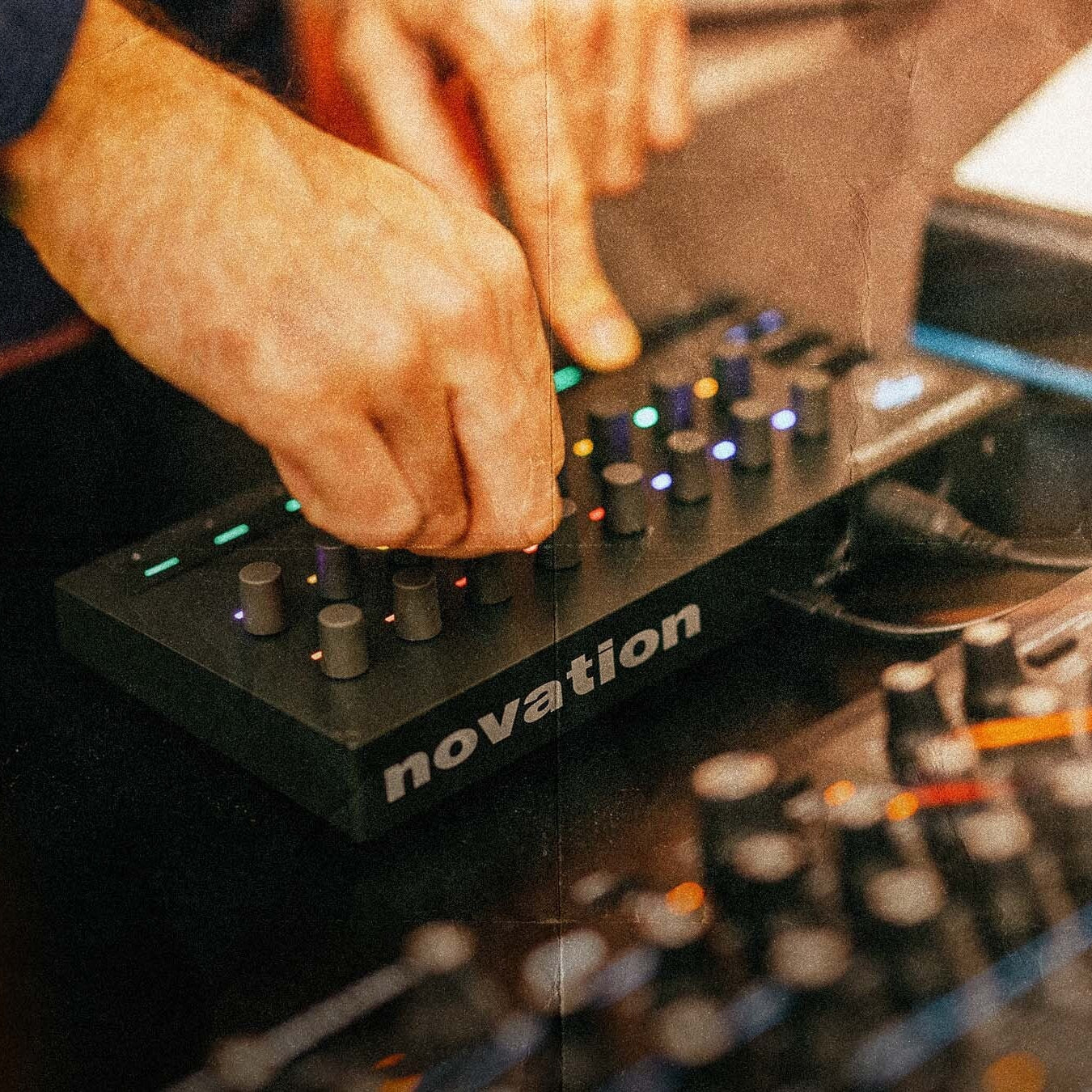Novation Launch Control 3 MIDI controller with knobs and pads, shown in a lifestyle setting for music production.