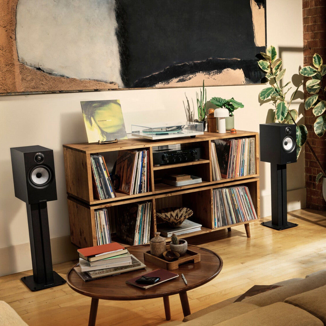 Bowers & Wilkins 606 S3 passive bookshelf speakers in black, shown with matching FS-600 S3 speaker stand on a modern living room setup.