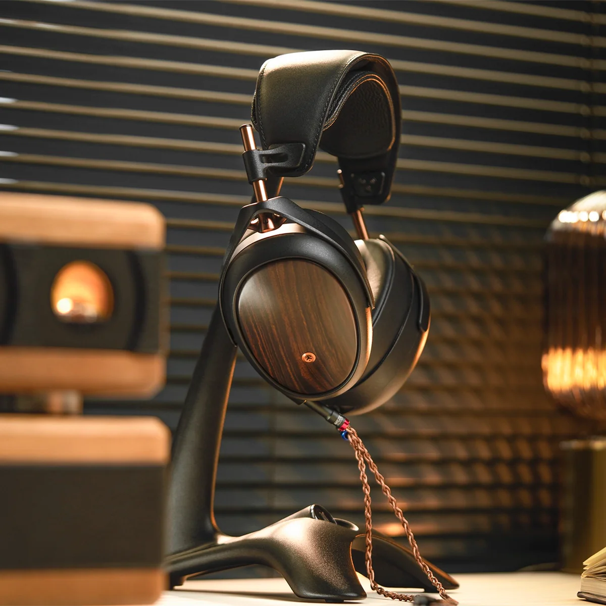 Close-up of Meze Audio Liric wired headphones showing the sleek black ear cups and detailed ear cushion design.