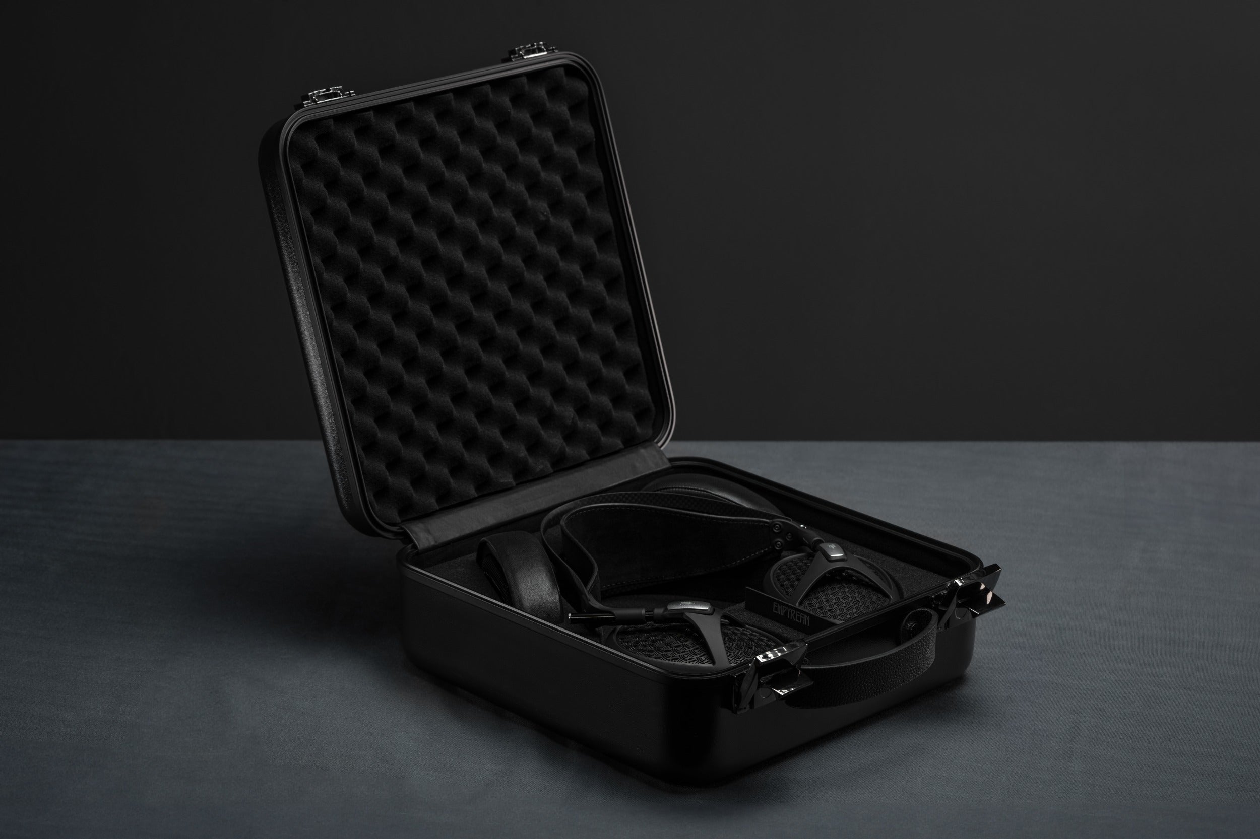 Open suitcase with Meze Audio Empyrean II wired headphones displayed inside, showcasing sleek design and premium craftsmanship.