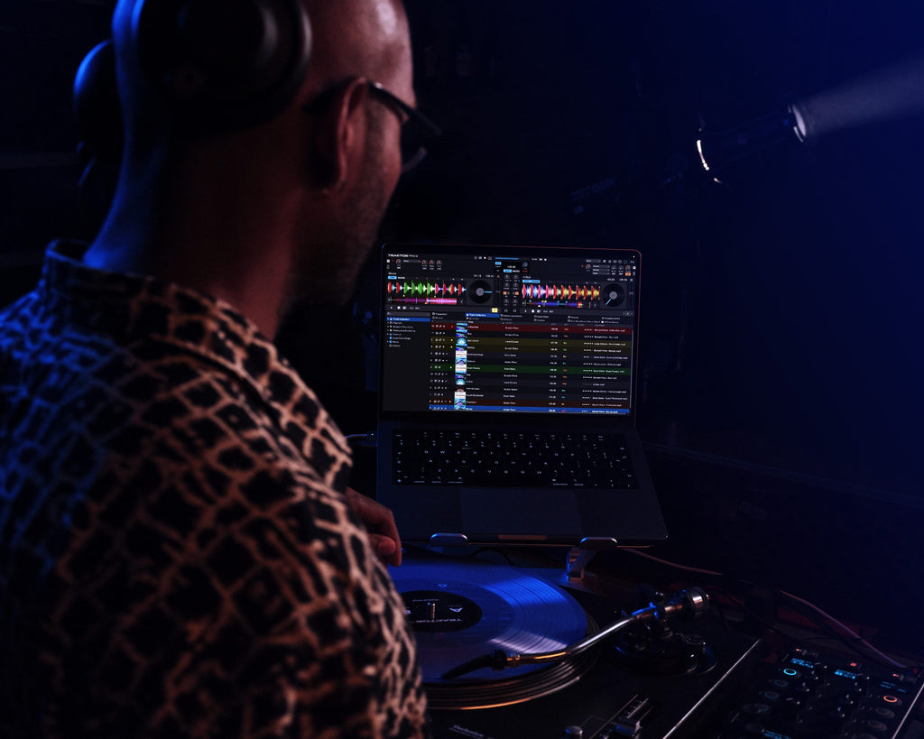 Native Instruments Traktor Pro 4 DJ software interface with mixing controls and waveform displays on a computer screen.