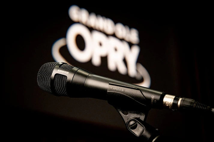 Shure Nexadyne 8/C dynamic microphone on a stand, professional audio equipment for live sound and recording.