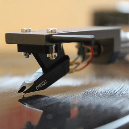 Ortofon Super OM 5E turntable cartridge installed on a record player, showcasing its stylus and cartridge body.