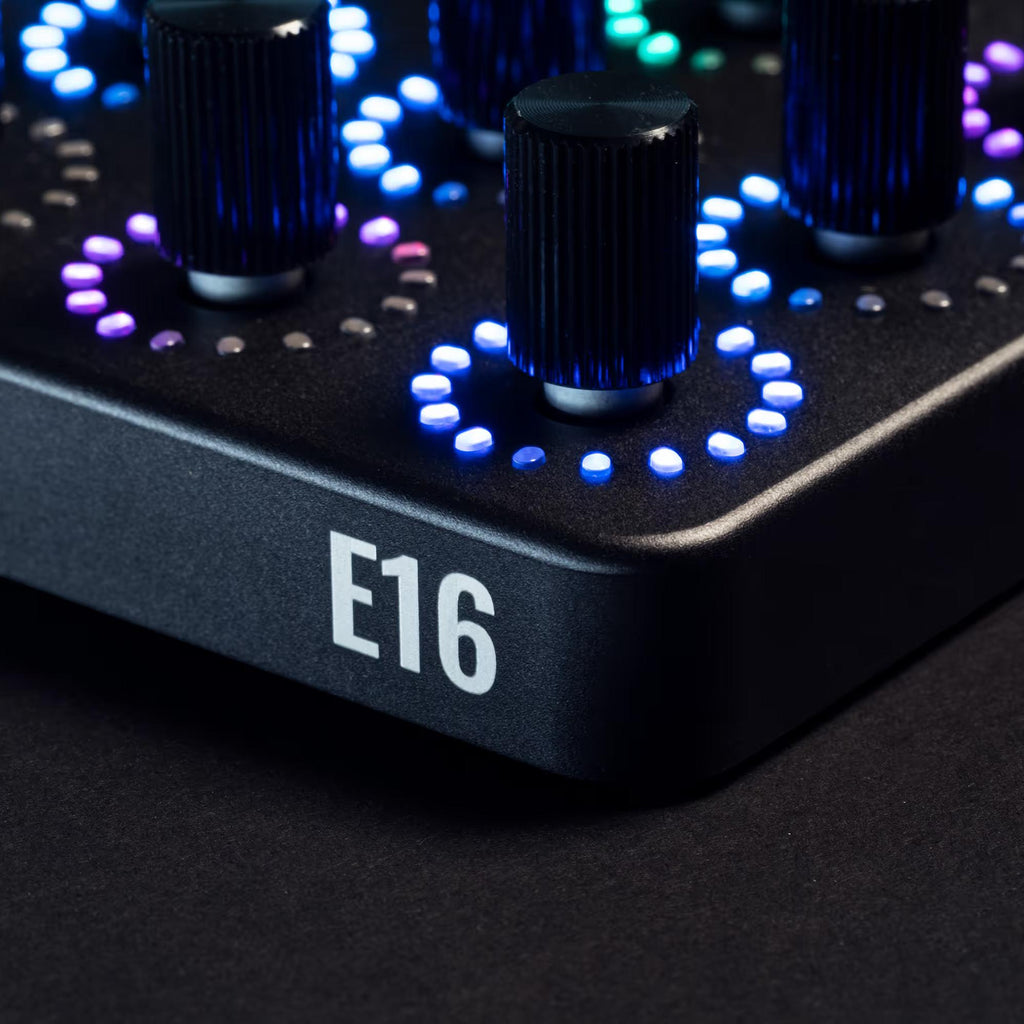 OXI Instruments E16 MIDI controller with multiple knobs and pads, shown in a corner view on a sleek black surface.