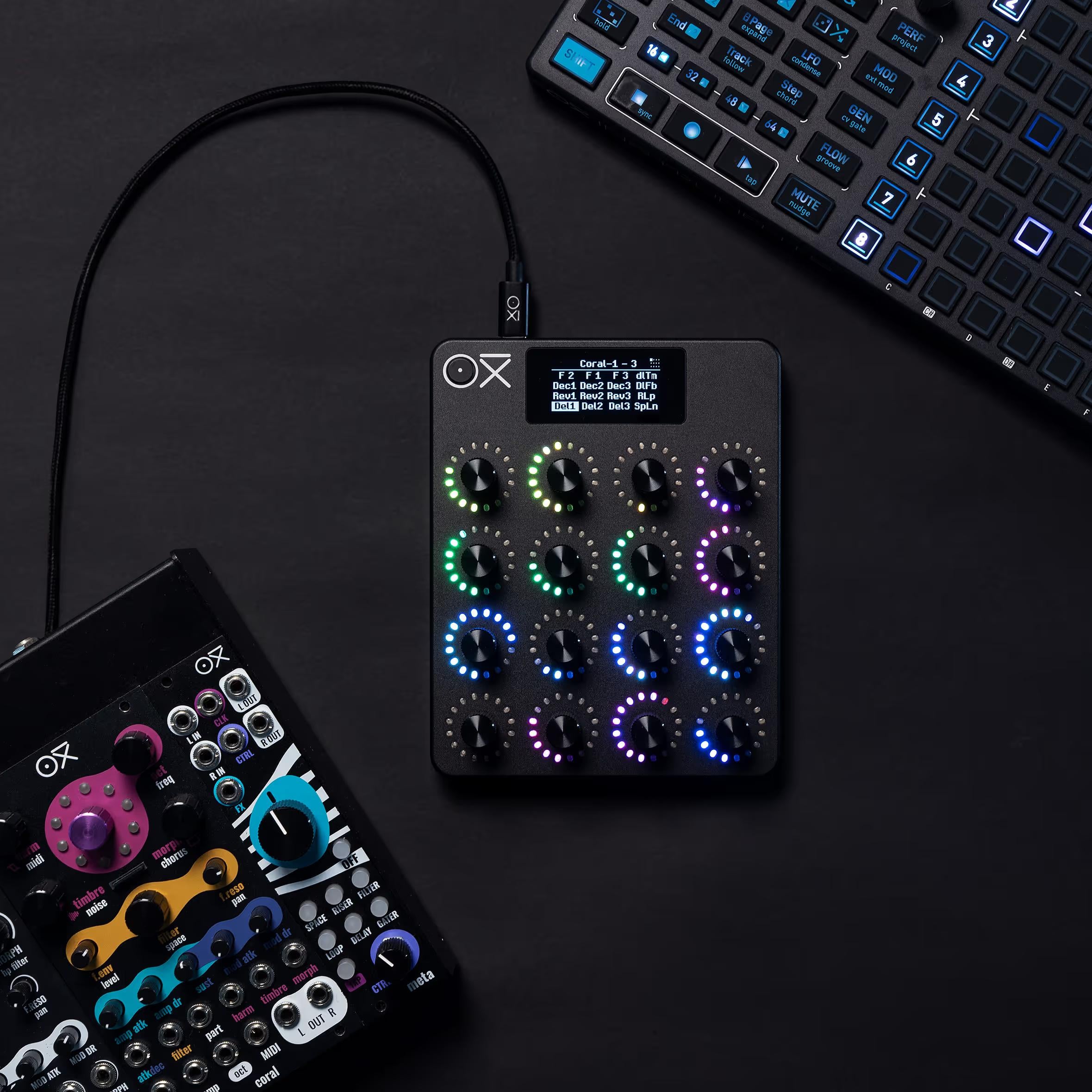 OXI Instruments E16 MIDI controller with multiple knobs and pads, shown in a group shot of OXI Instruments MIDI controllers.