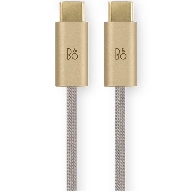 Bang & Olufsen Beoplay H100 wireless headphones with fabric cable and sleek hourglass design, shown in sand color.