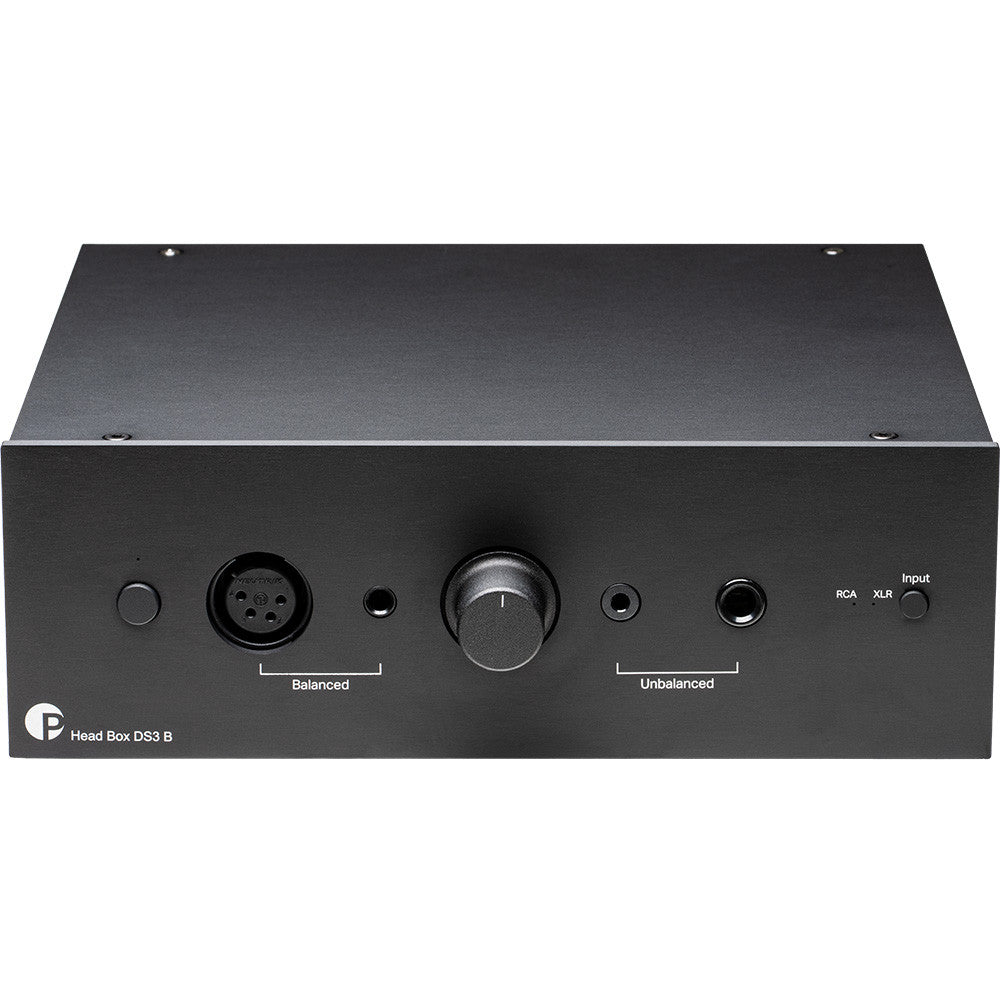 Pro-Ject Head Box DS3 B headphone amplifier and DAC with sleek black design and control knobs, set on a wooden surface.