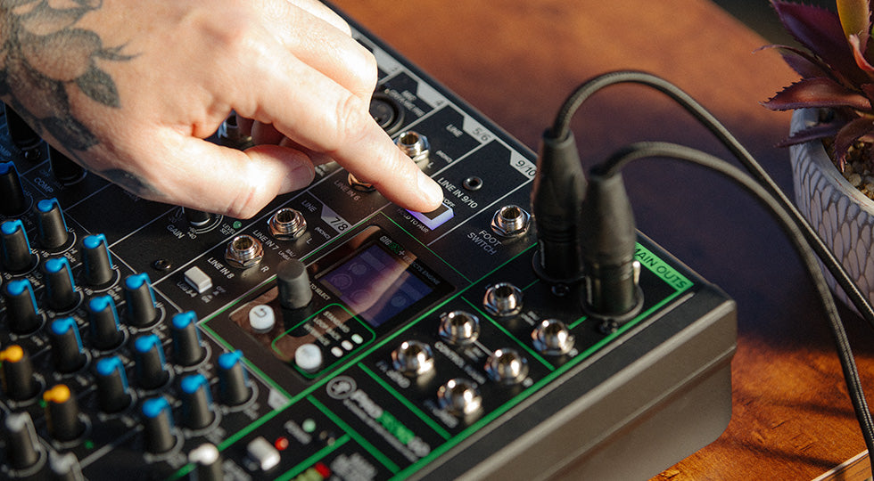 Mackie ProFX10 GO analog mixer with multiple input channels, knobs, and connection ports on a dark background.