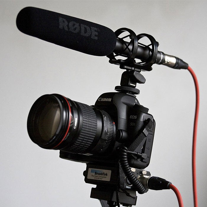 Rode NTG2 shotgun microphone mounted on a boom pole, professional audio recording equipment for film and video production.