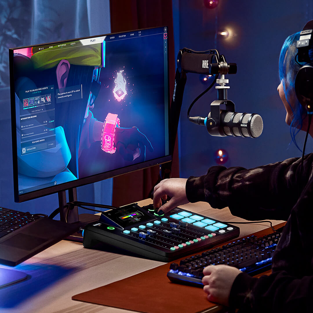 Rode RodeCaster Pro II digital mixer with customizable controls, shown in a gaming setup with colorful background lighting.