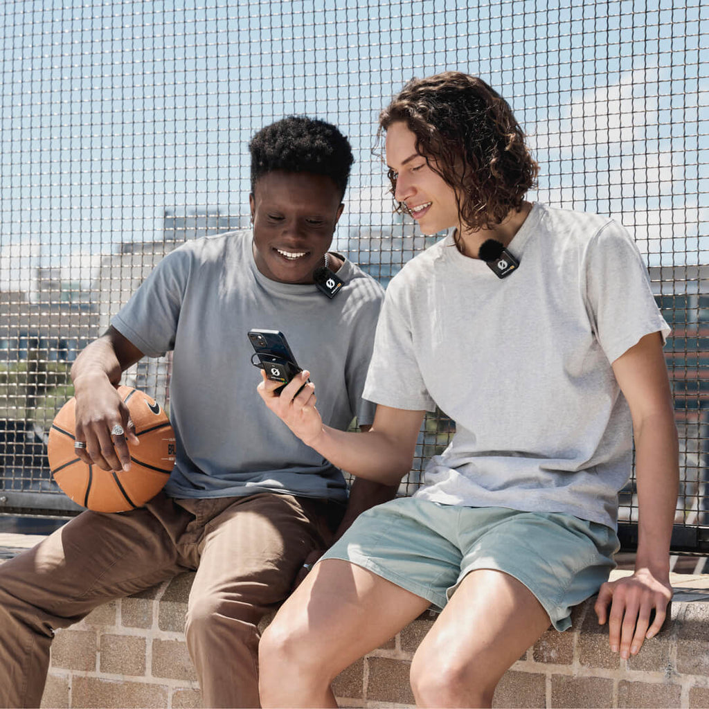 Rode Wireless ME Dual creator wireless microphone system in black, shown in use during basketball review, with a basketball in the background.