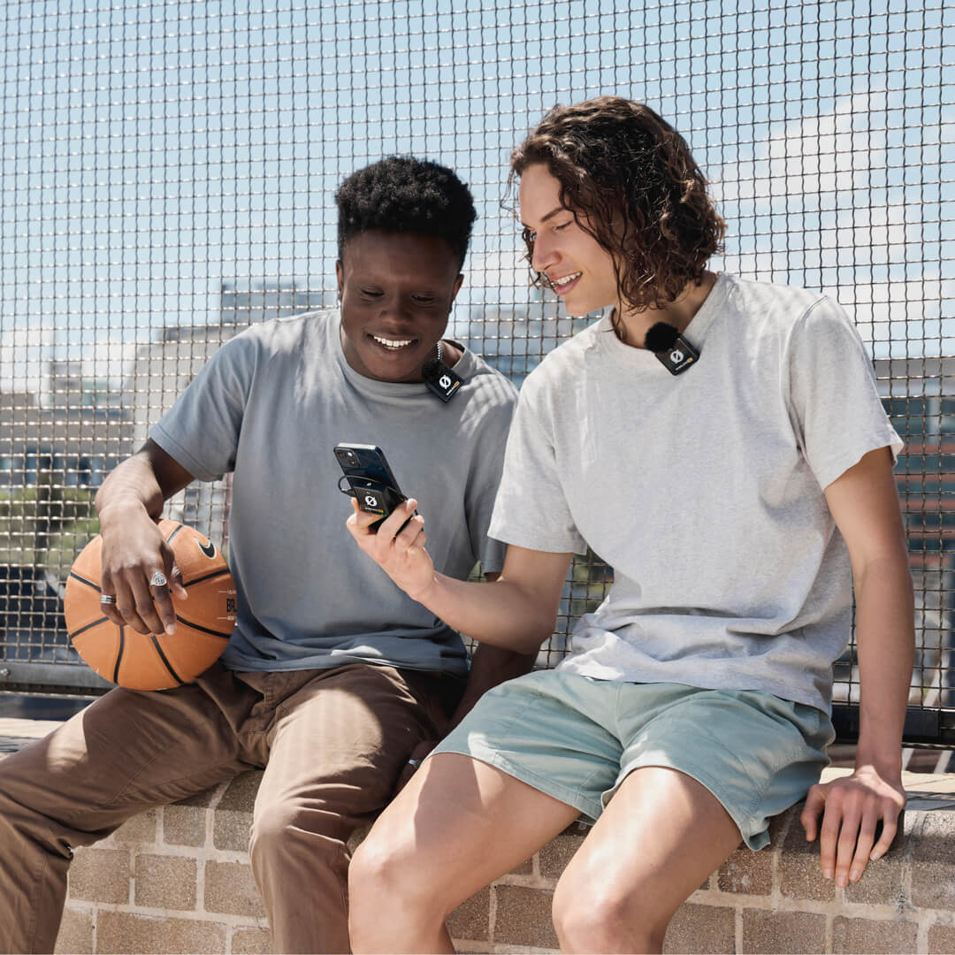 Rode Wireless ME Dual creator wireless microphone system in black, shown in use during basketball review, with a basketball in the background.