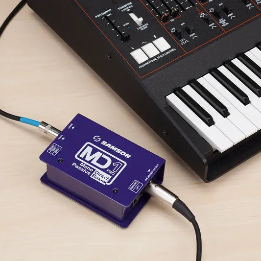 Samson MD1 Pro DI box connected to a keyboard, showing input and output jacks for professional audio signal sharing.