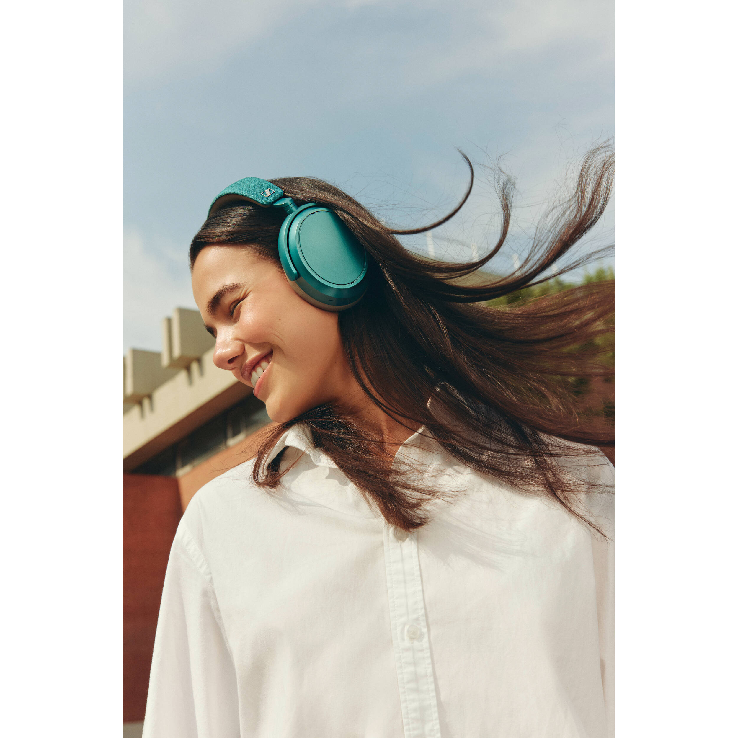 Sennheiser Momentum 4 Wireless headphones, lifestyle worn by a woman, petrol blue