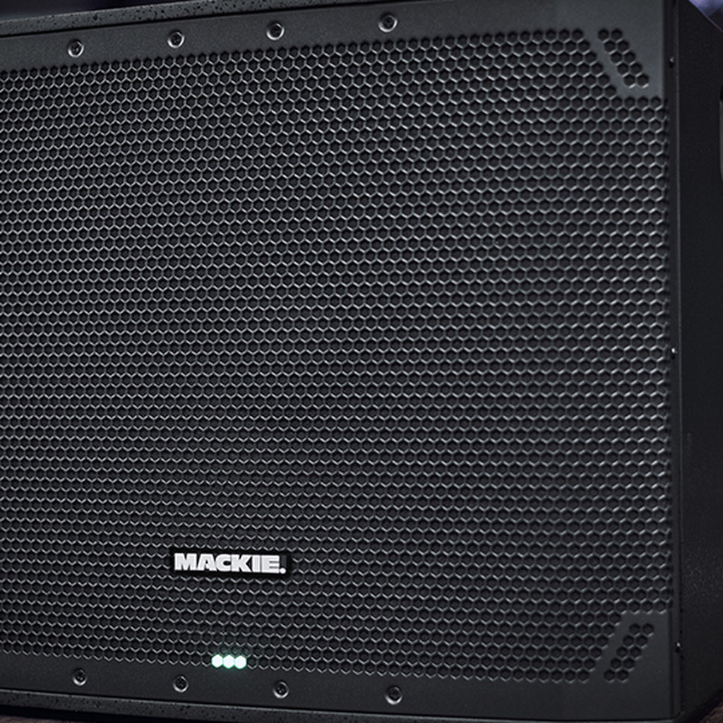 Close-up of Mackie Thump15Sv4 active subwoofer showing its rugged speaker grille and control panel for powerful bass output.