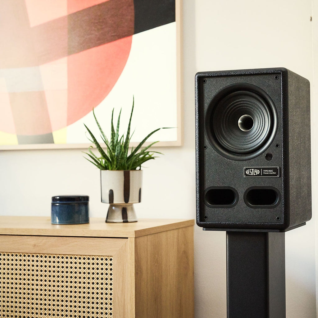 Vestlyd M-Stands holding a Vestlyd M6C Active in Black next to a sideboard