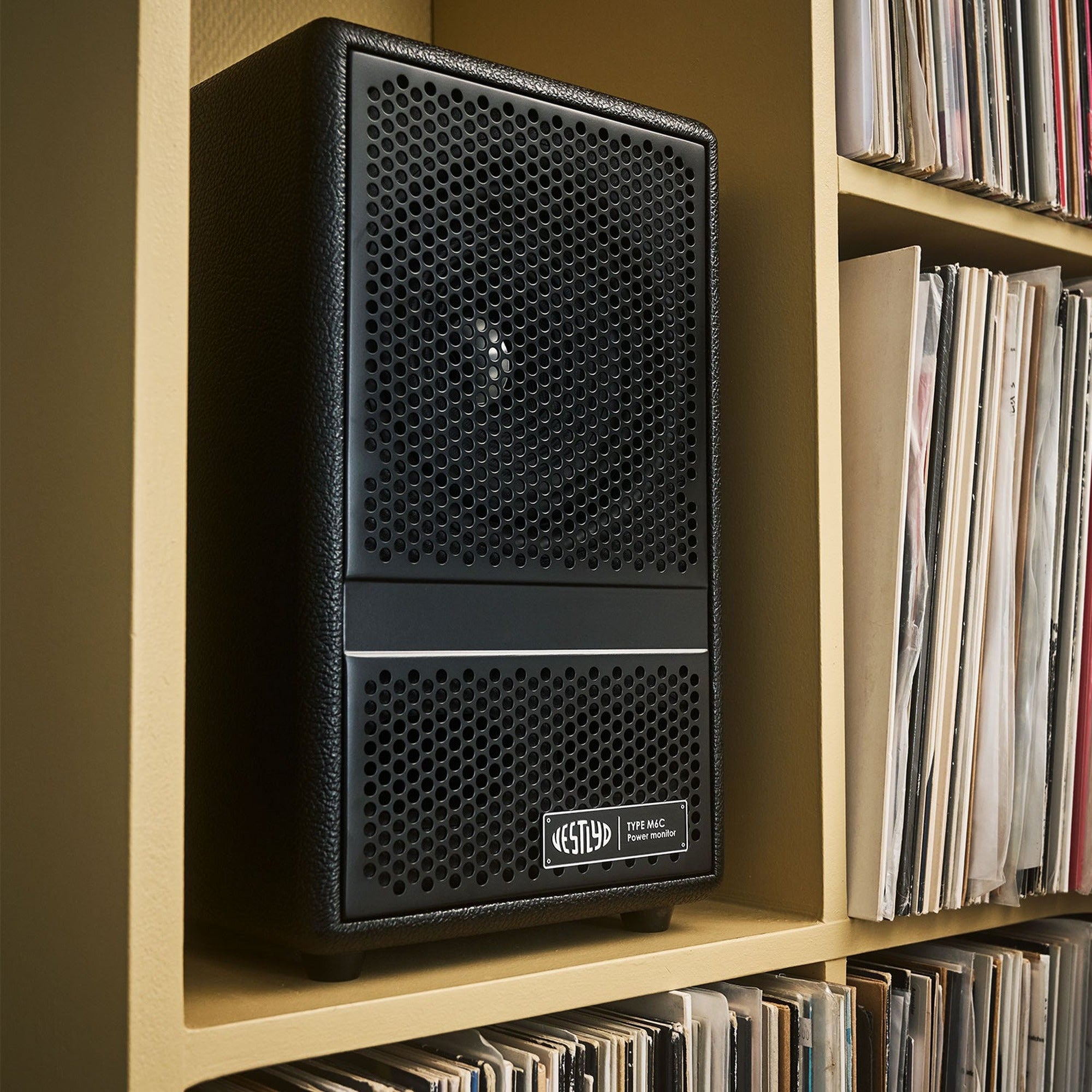 Vestlyd M6C Active in Black placed on a record shelf in a living room
