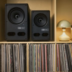 Vestlyd M8C Active and M6C Active in Black side by side on a shelf above vinyl records