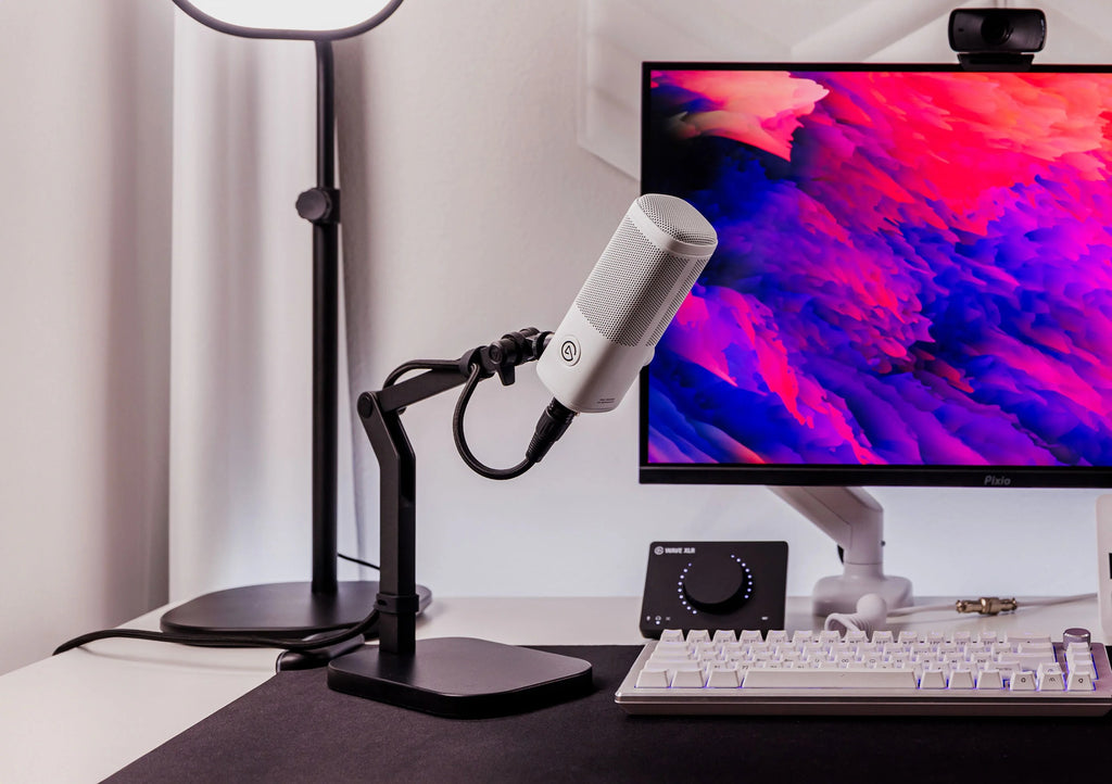 Elgato Wave Desk Stand holding a desktop microphone, shown in a modern workspace setup with a clean background.