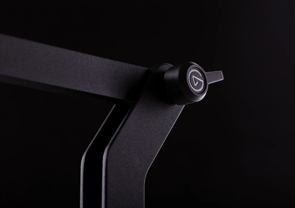 Elgato Wave Desk Stand holding a desktop microphone on a workspace with a computer and accessories.