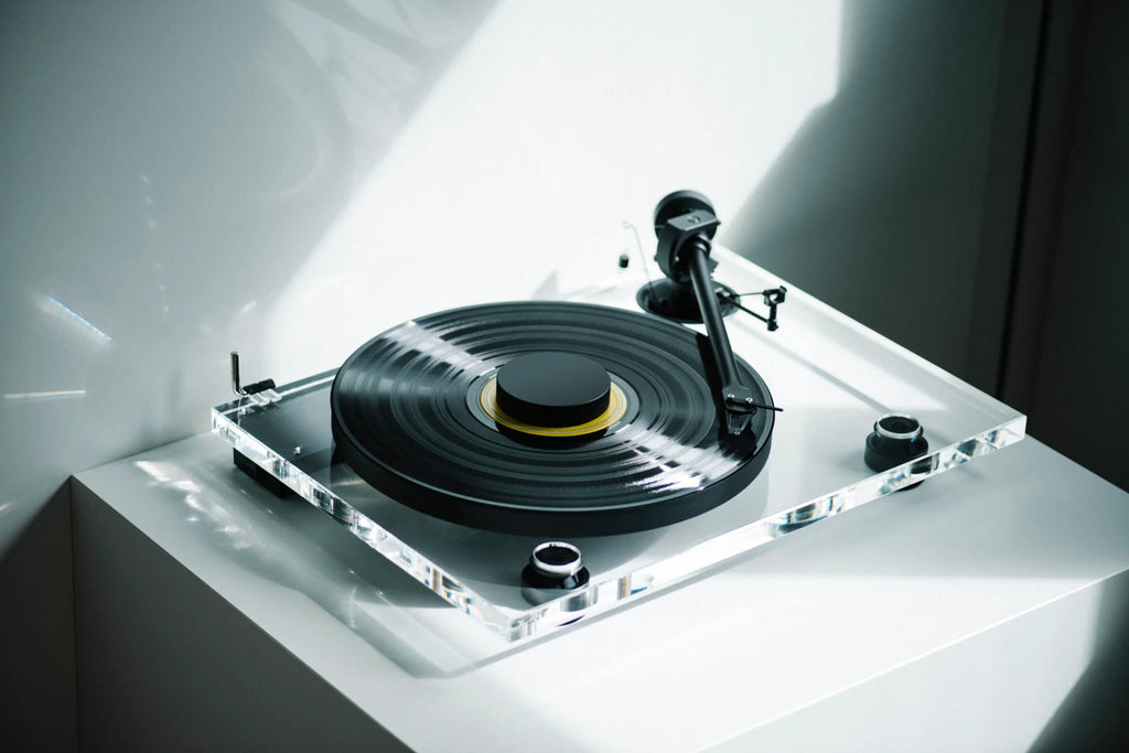 Pro-Ject XA B turntable with wooden plinth and tonearm, shown in a stylish modern setup for high-quality vinyl playback.