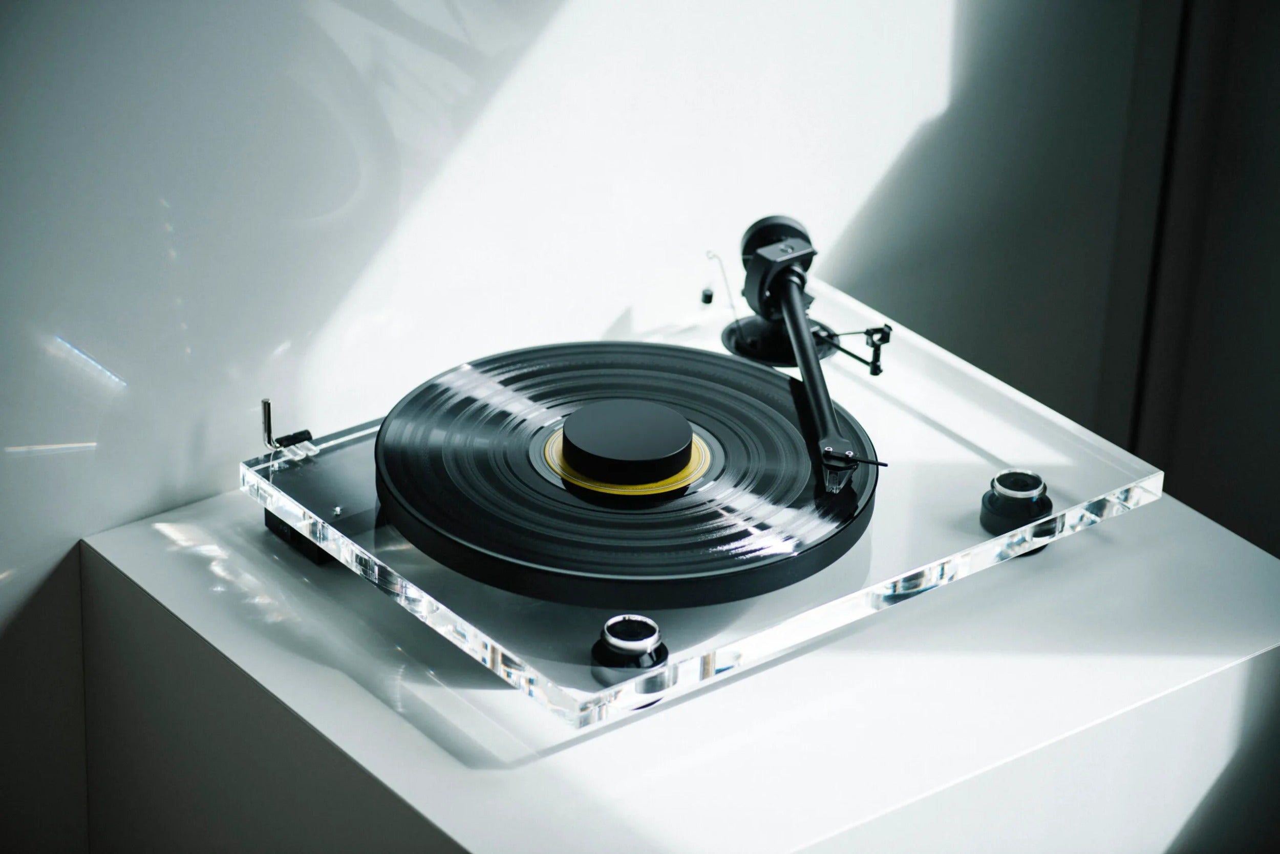 Pro-Ject XA B turntable with wooden plinth and tonearm, shown in a stylish modern setup for high-quality vinyl playback.